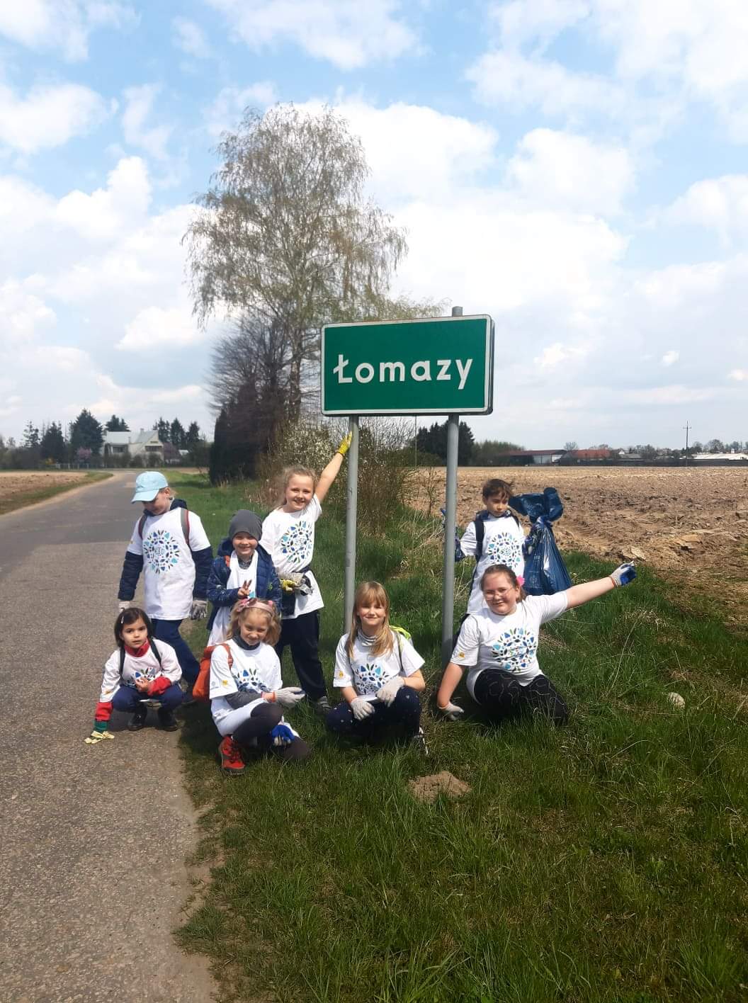 grupa dzieci przy znaku Łomazy